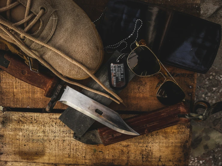 a pair of sunglasses, hat and knife lying on a table