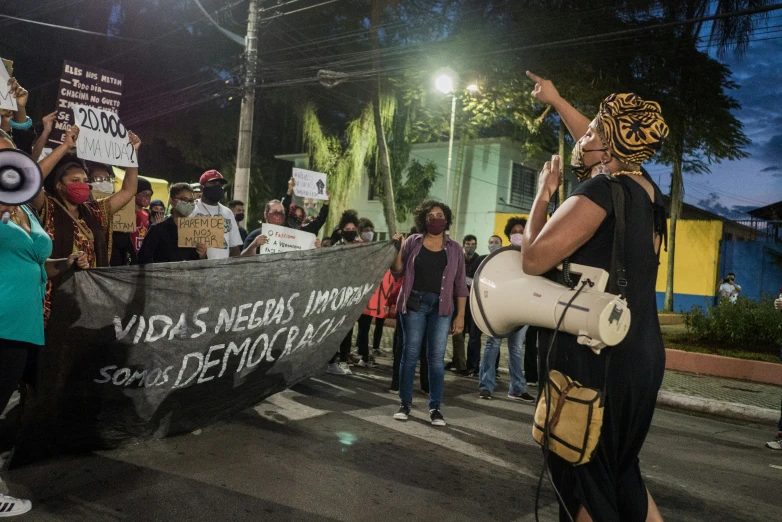 a woman holds a loud - up sign while holding a drum