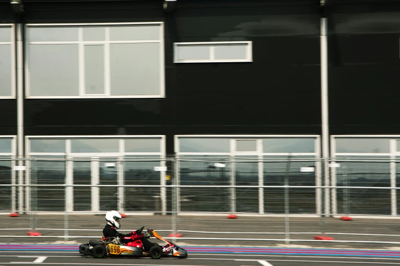 two go carts going by an industrial building