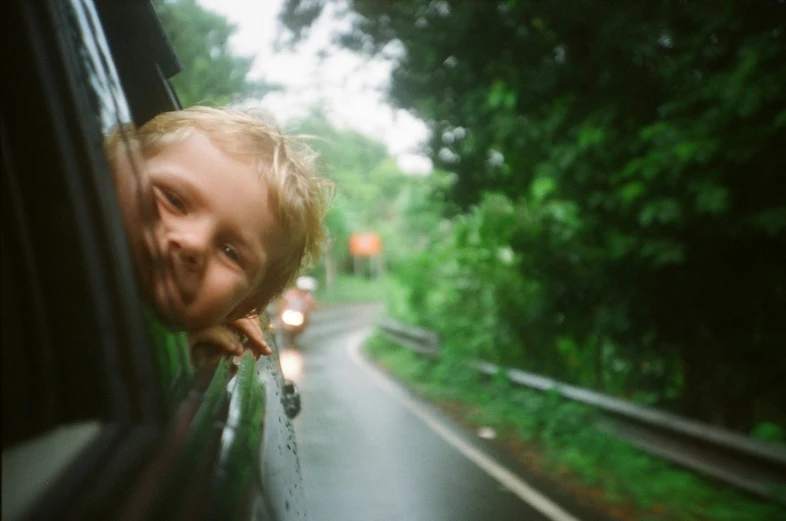 a child looking out the window of a car