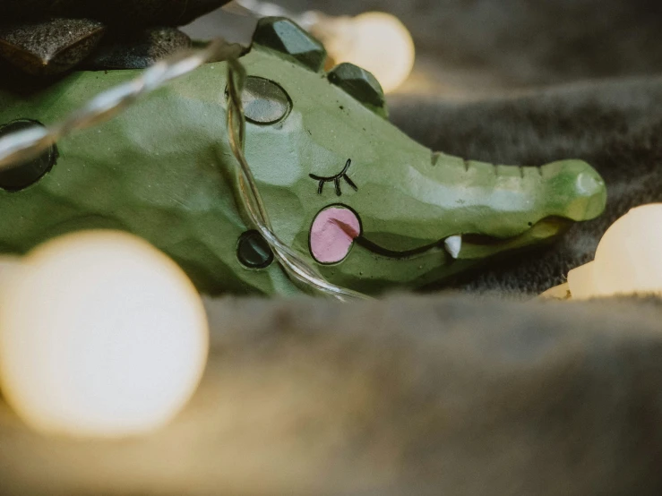 a cat that is holding onto a green stuffed animal