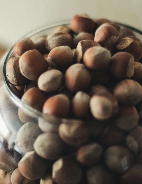 a glass jar of nuts sitting on top of a counter