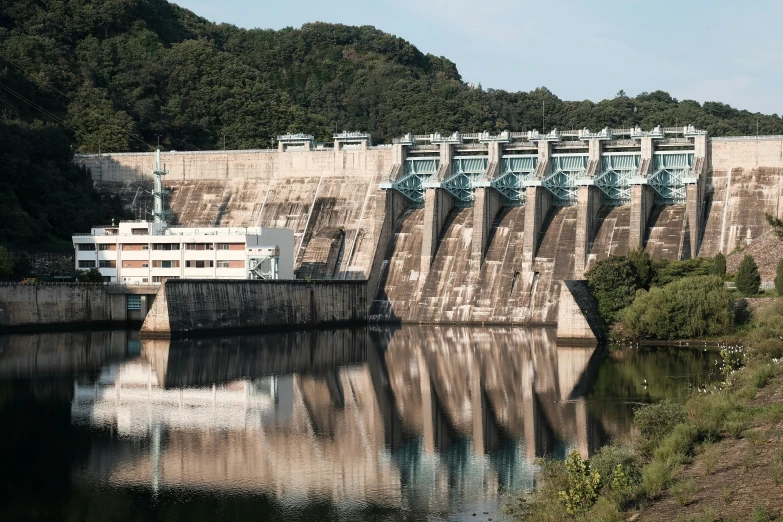 a boat moving along the water past an elaborate concrete wall