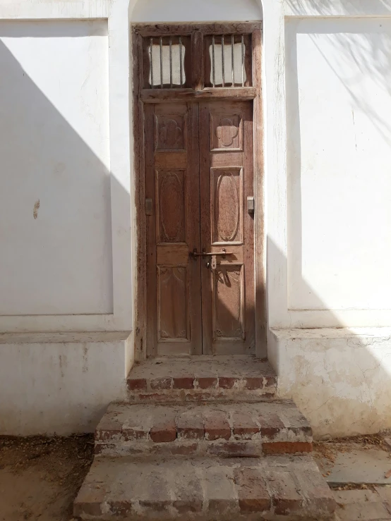 an open wooden door sitting in front of a stone building