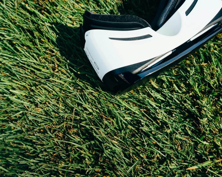 a white and black shoe sitting in the grass