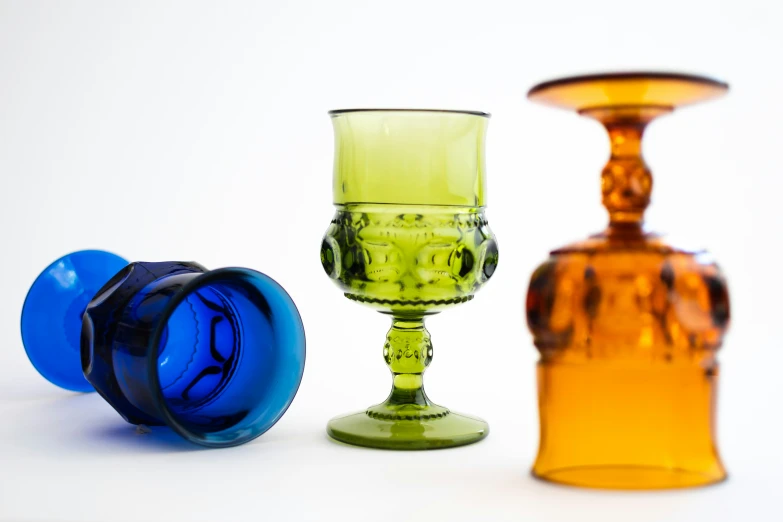 two colorful glass vases and one blue one