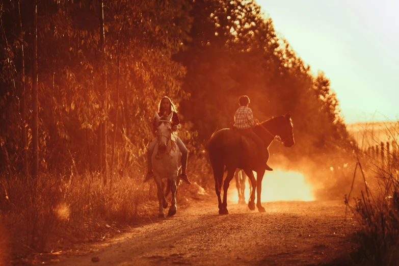 two women on horseback riding on a dirt road