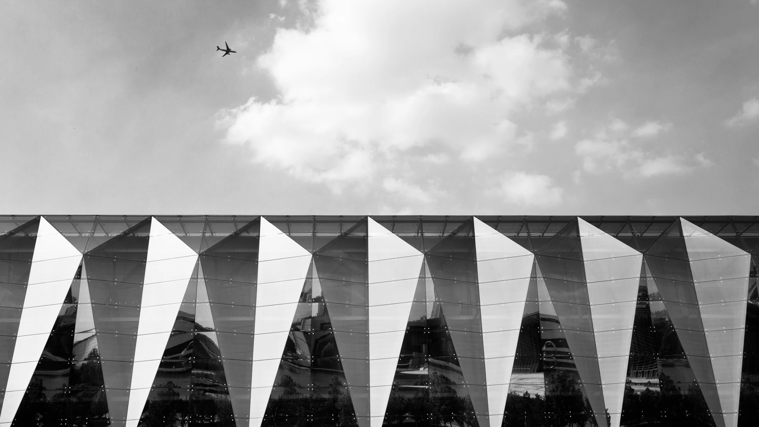 an airplane is flying over a futuristic building