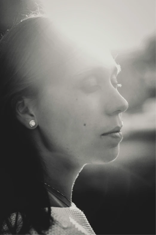 a woman wearing earring's standing in sunlight