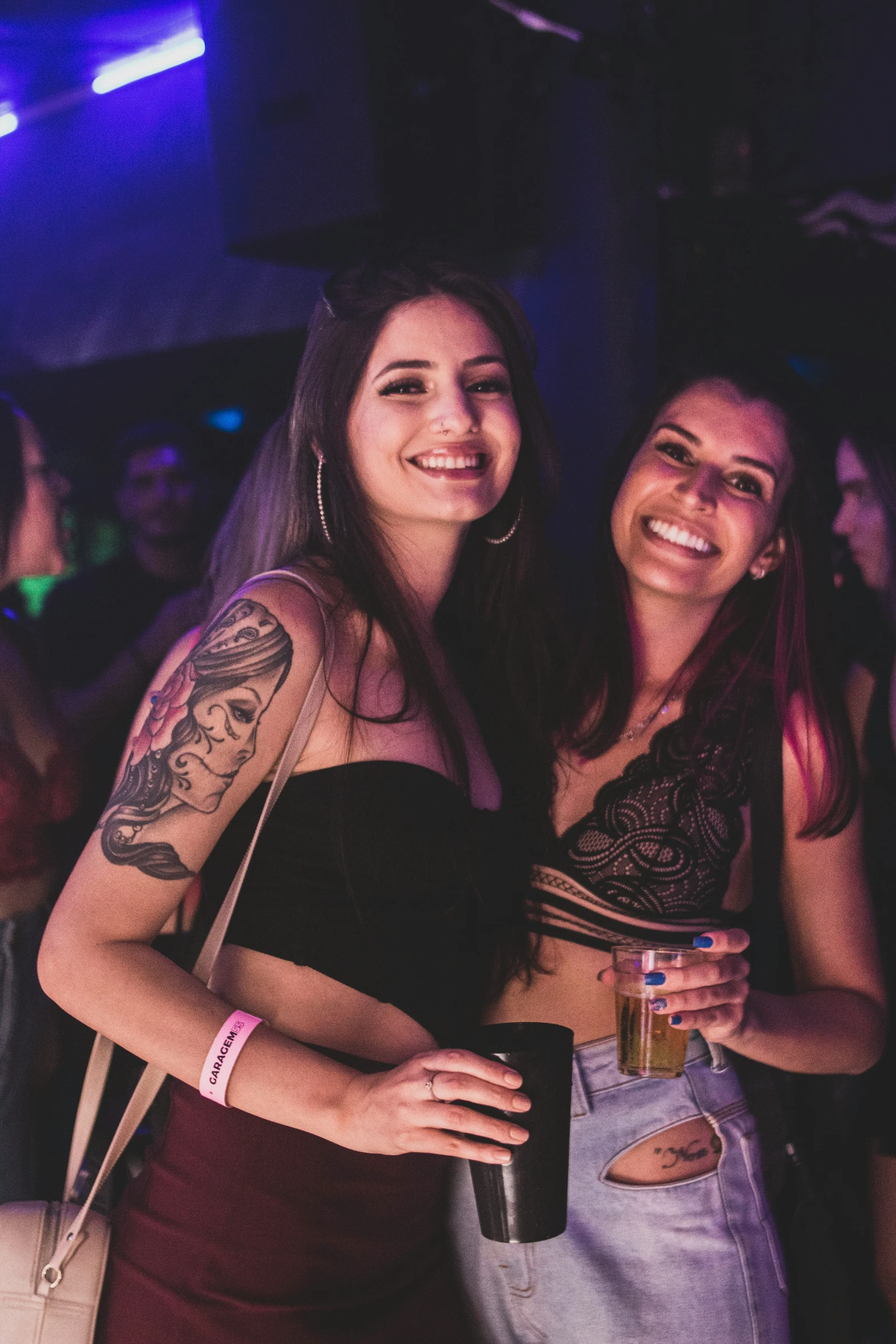 two young women in the background smiling and drinking