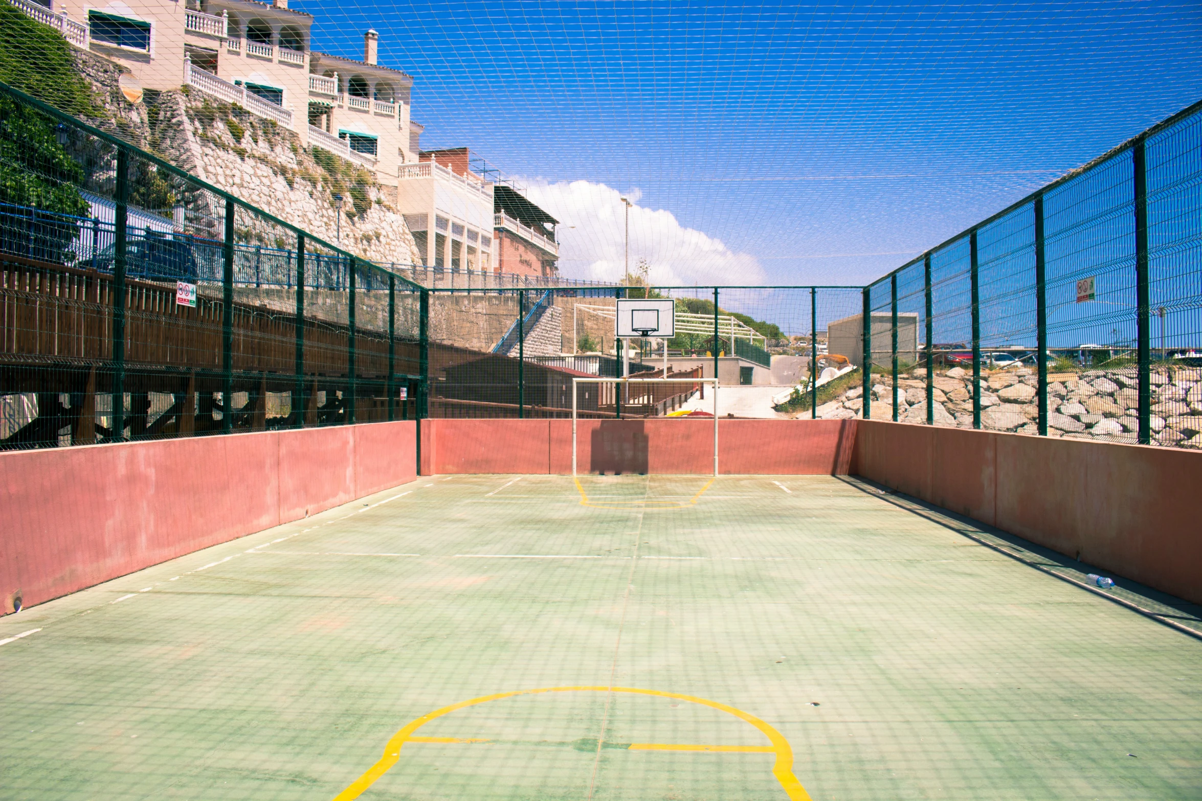 an empty tennis court in front of the city