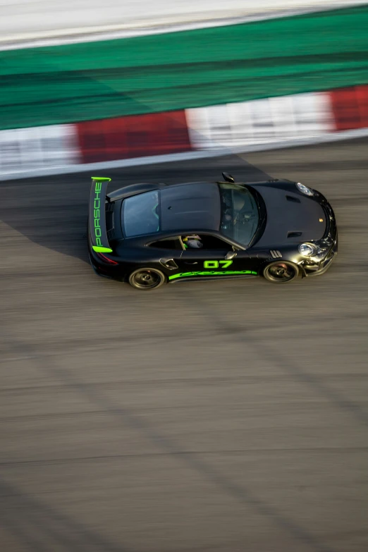 an overhead view of a small black car on a track