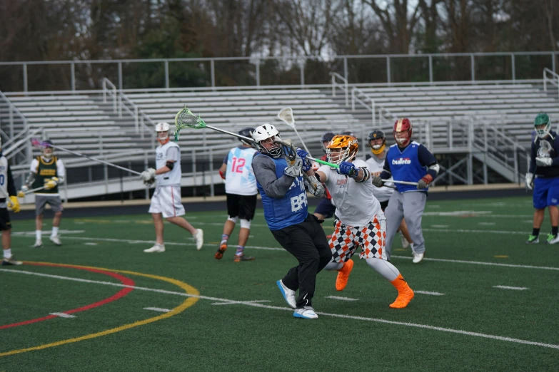 s playing lacrosse on a field with bleachers and bleachers