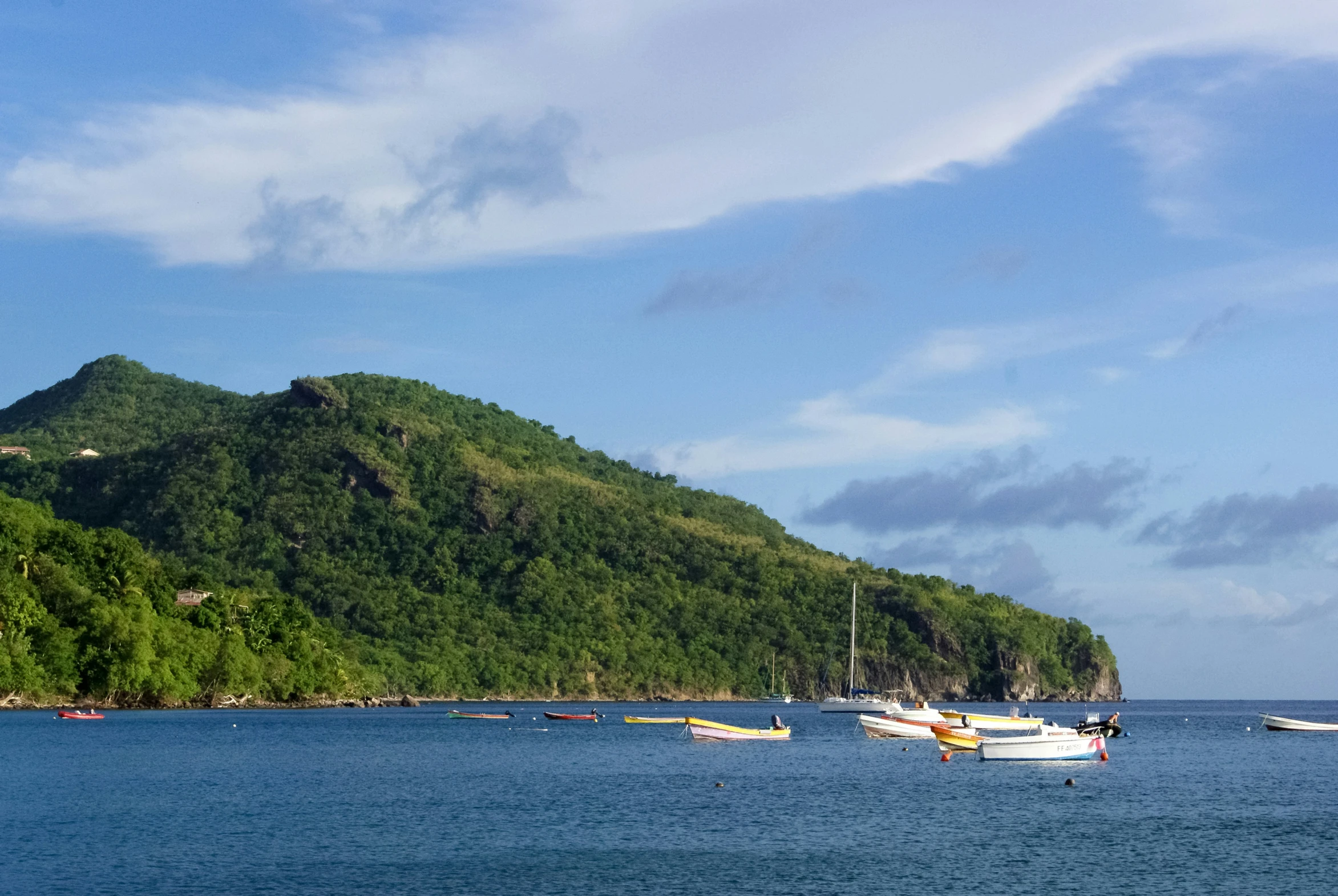 the water is calm and there are many boats near the shore