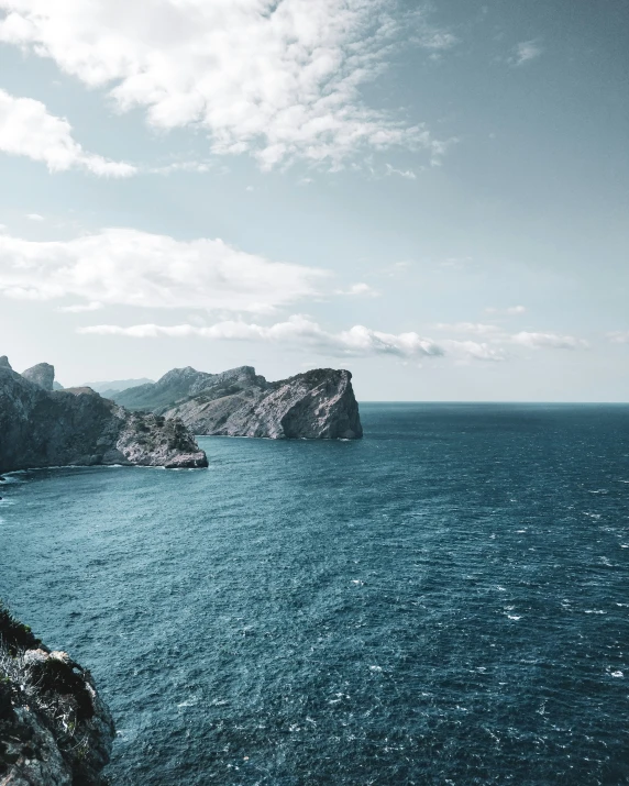 the view of the blue ocean with rocks in the distance