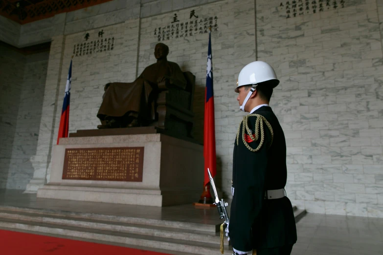 man in uniform standing in front of statues