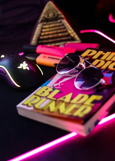 a book, mouse, sunglasses and some lights