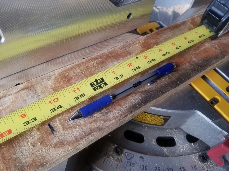 tape measures are being measured on the edge of a piece of wood