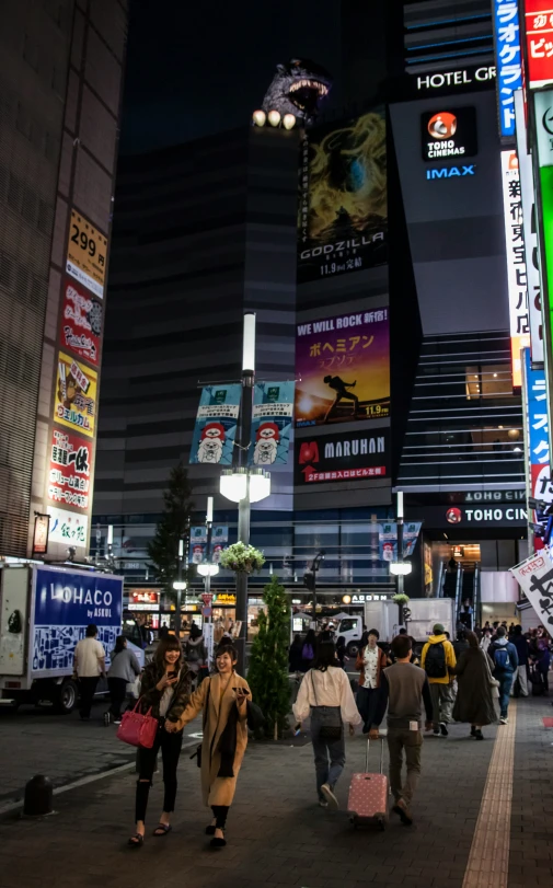 many people walking down a street while some have luggage