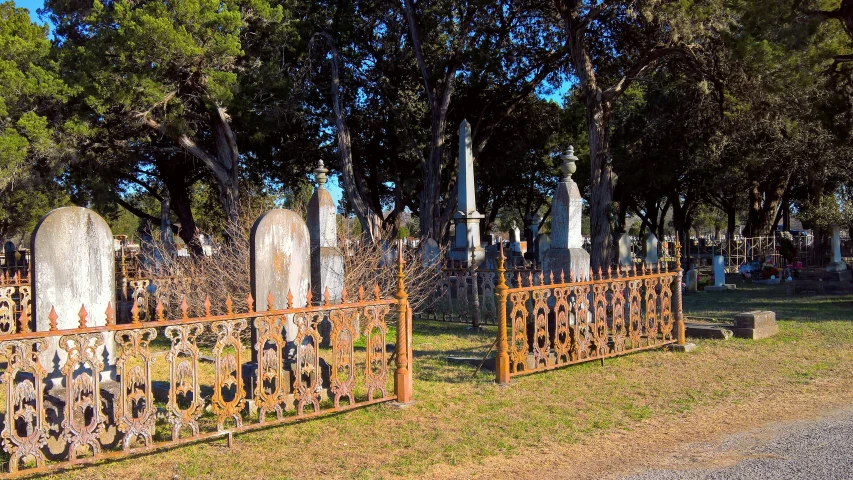 a row of tombstones next to trees and dirt