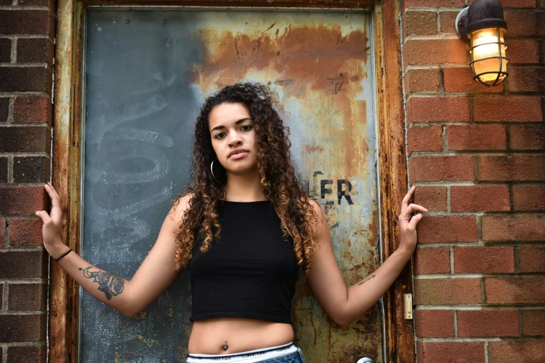 a woman in short shorts standing outside of a door