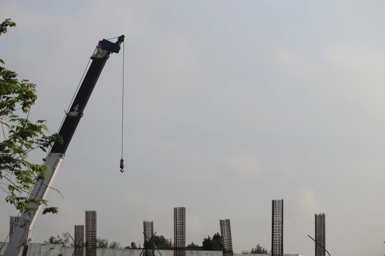 a crane lifting a crane on top of a tall tower