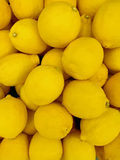 yellow lemons that are stacked up together