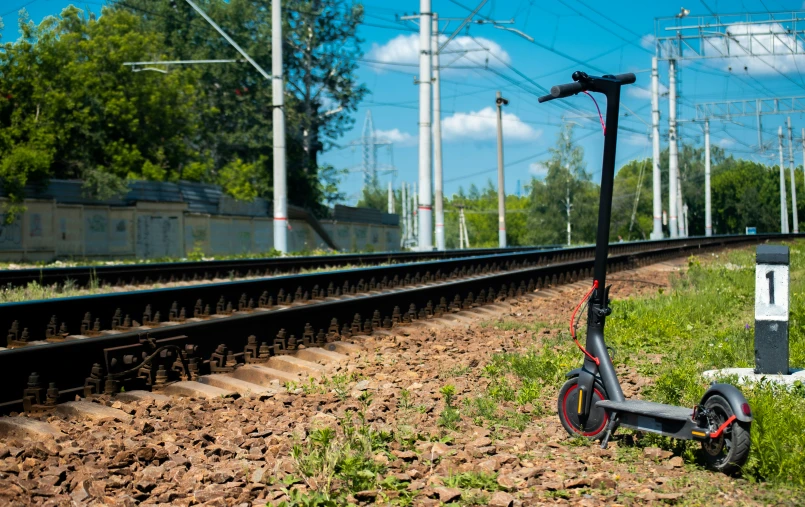 scooter parked on the tracks next to a railroad crossing