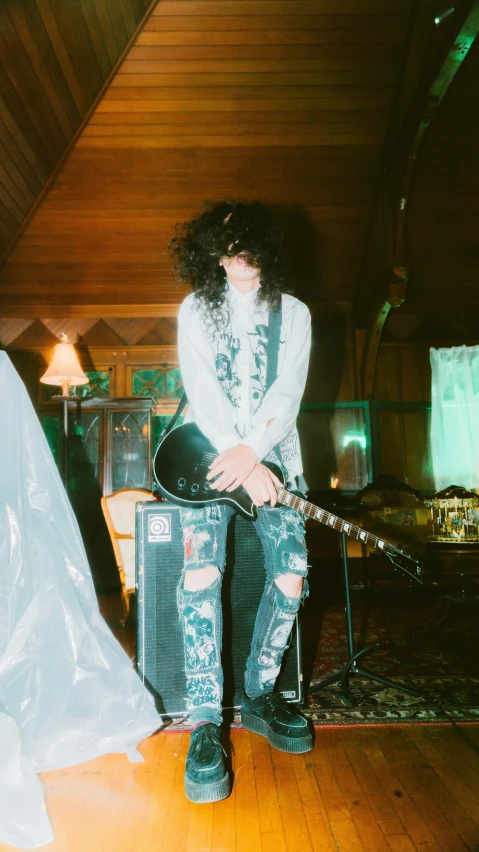 a man standing on a floor with his guitar