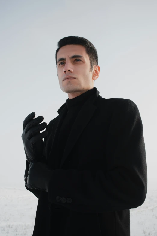 a man is in a black suit and black gloves