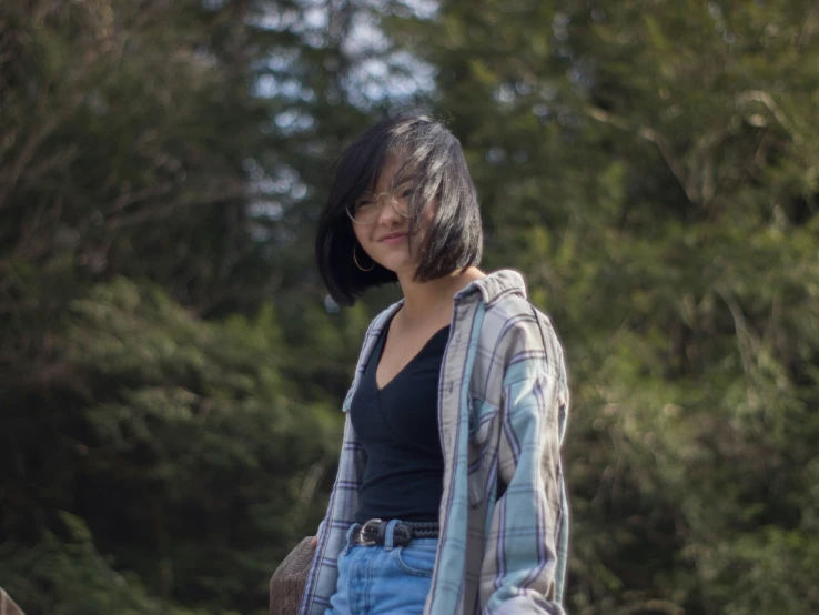 a girl in the woods wearing ripped jeans