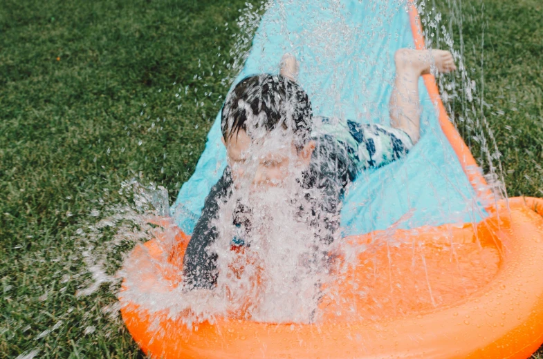 a boy and girl in a pool on an orange rubber raft