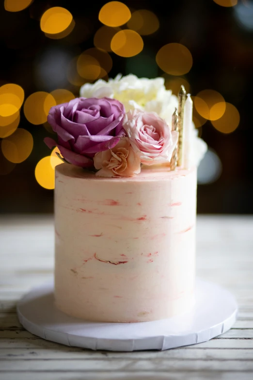 a white cake with frosting and a flower on top