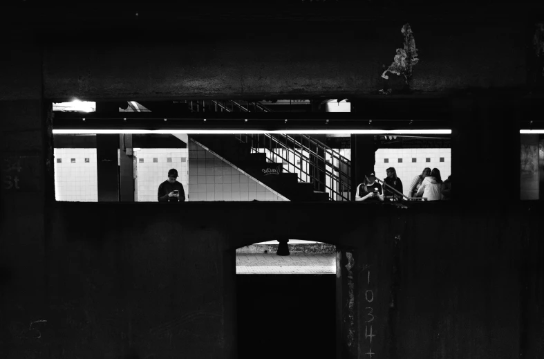 a man and woman standing outside a tunnel at night