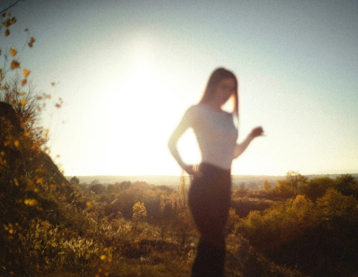 a woman is standing by a mountain during the day