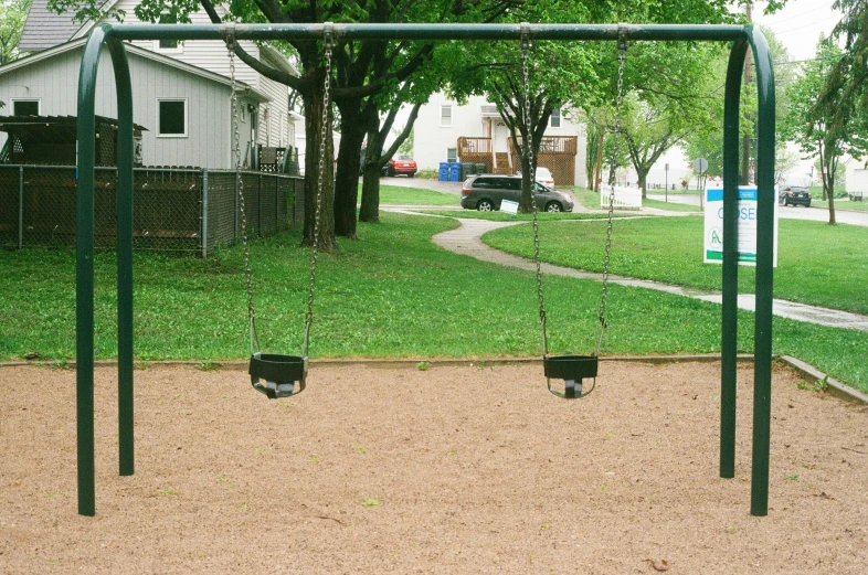 some swings in a park on dirt ground
