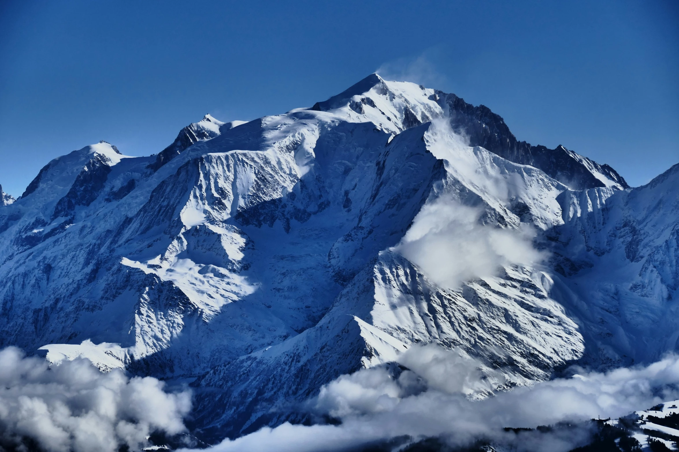 a huge mountain with lots of clouds floating over it