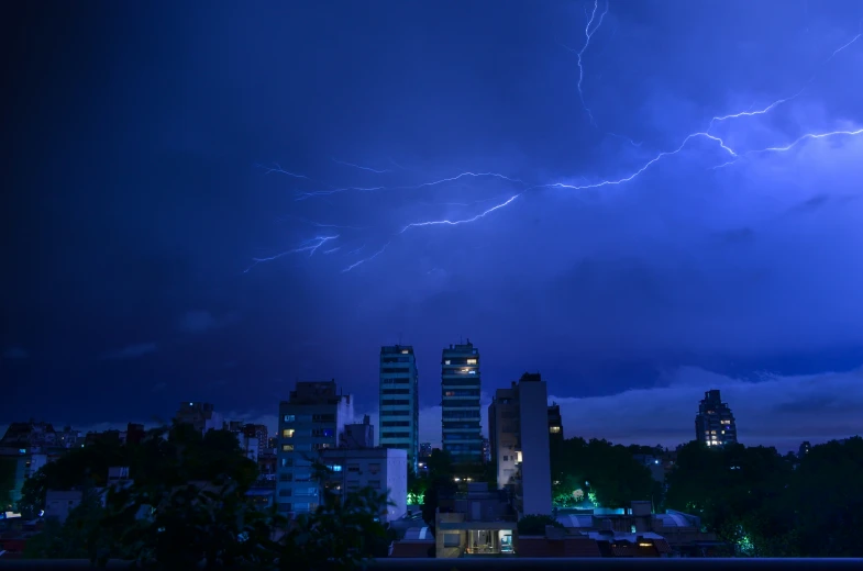 lightning strikes over the city at night in an urban setting