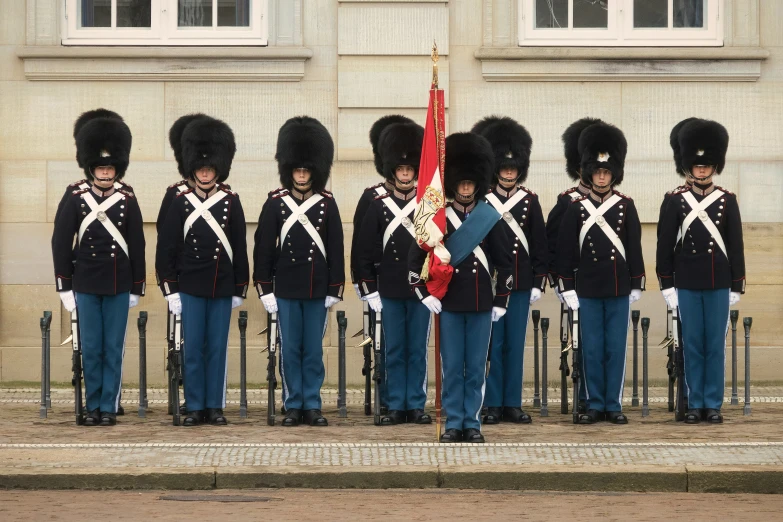 a group of soldiers standing around each other near a building