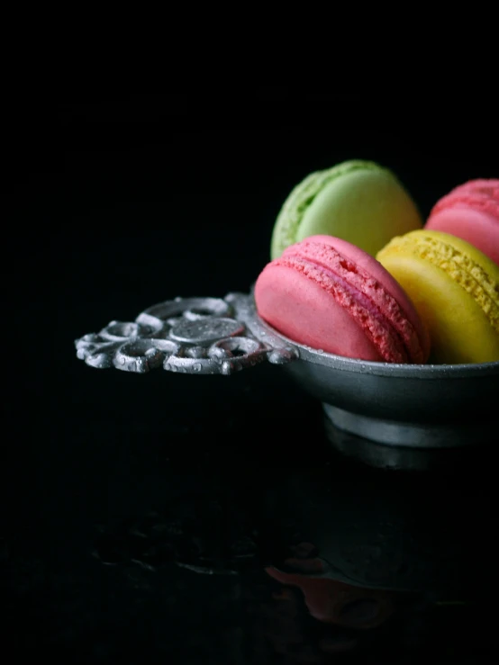 four macaroons are in a bowl on a table