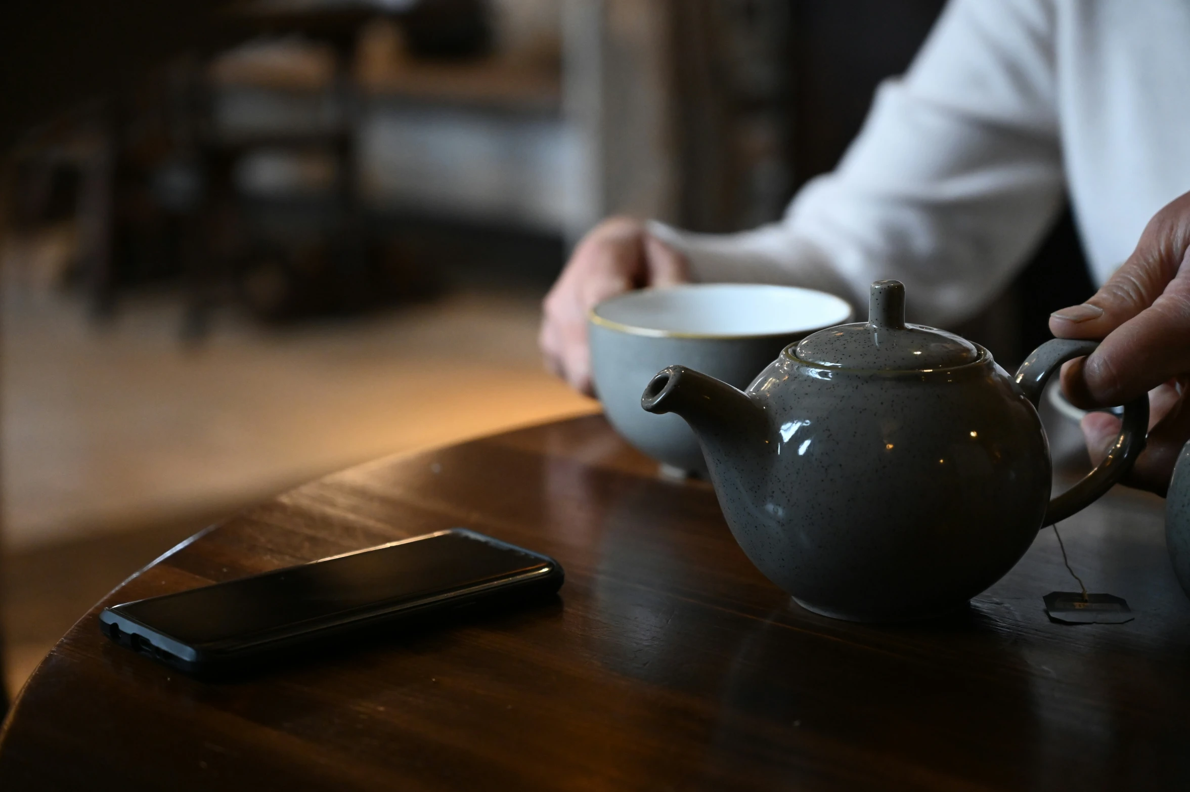 there is a teapot with a silver lid on a wooden table