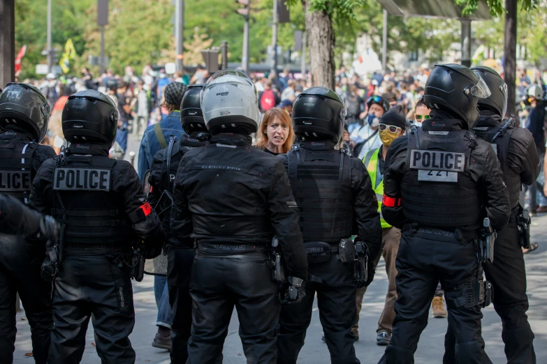 a woman standing in front of police on their backs