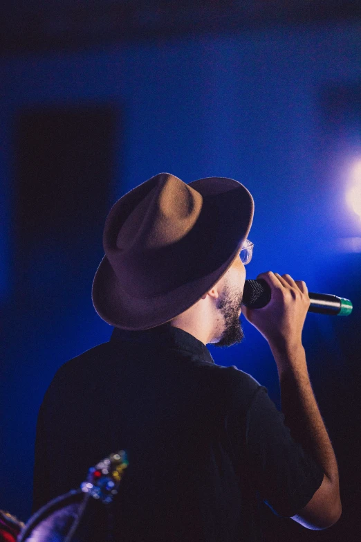 a man with a fedora is talking on the phone