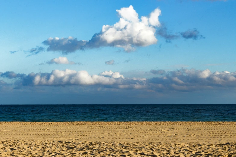 a white bench sitting in front of the ocean on a sunny day