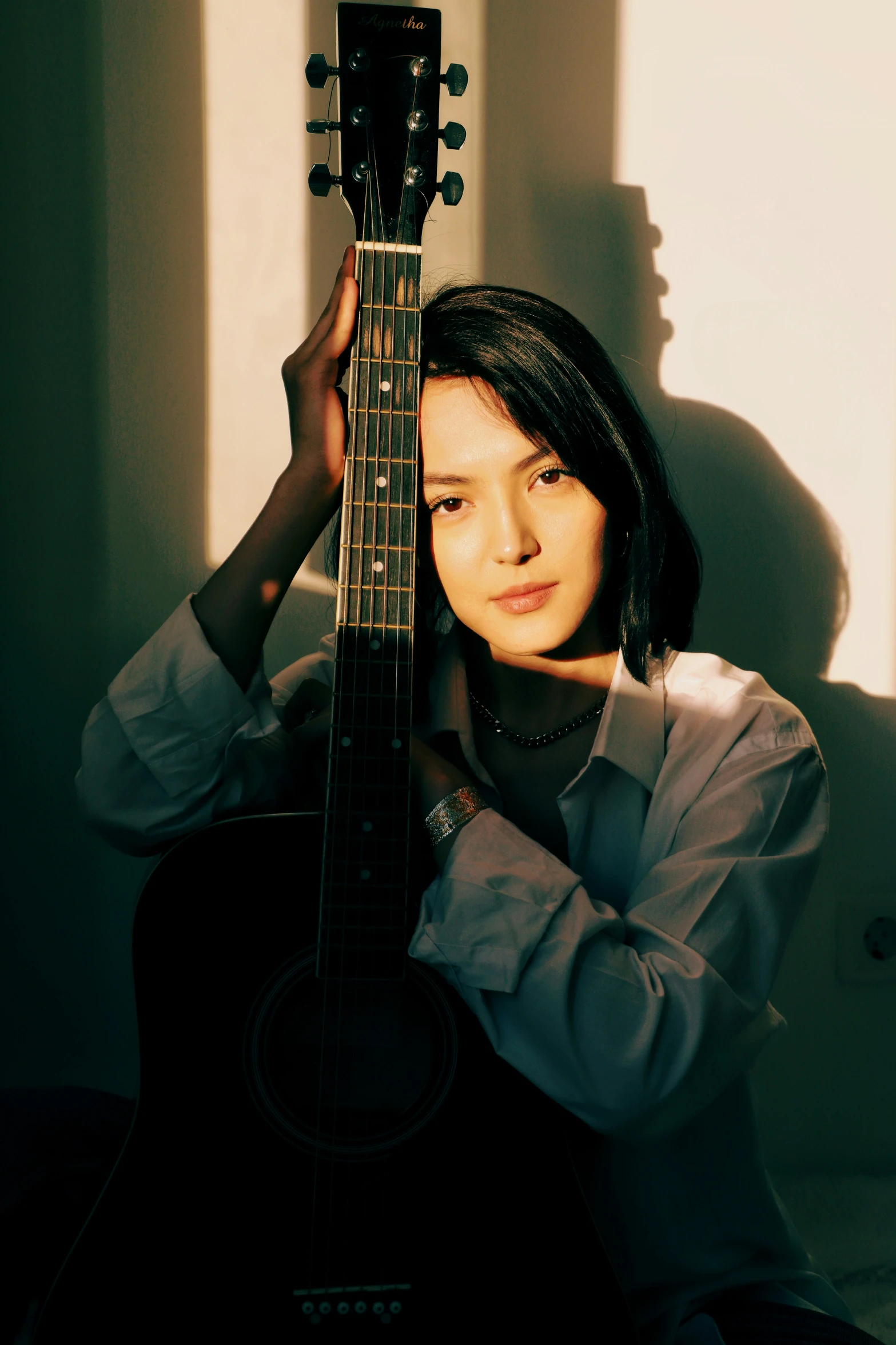 a young woman holding onto her guitar