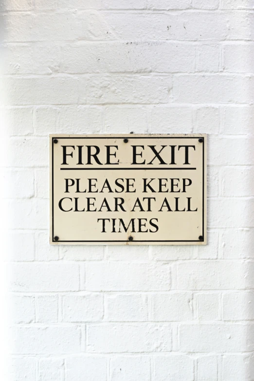 a sign with words fire exit please keep clear at all times