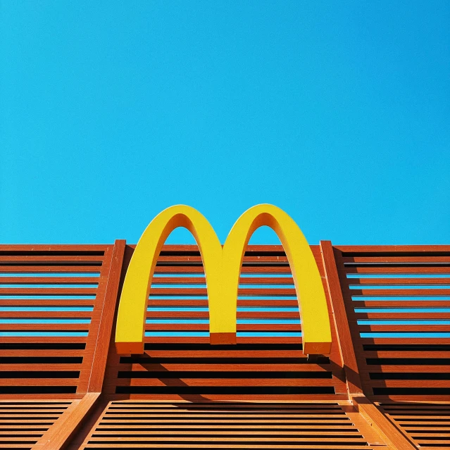 a wooden bench topped with a yellow mcdonald's sign
