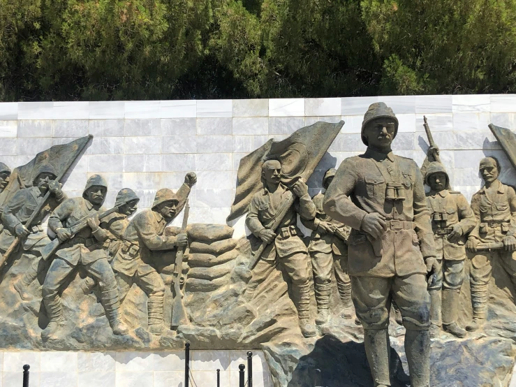 the statue depicts a group of men marching with spears