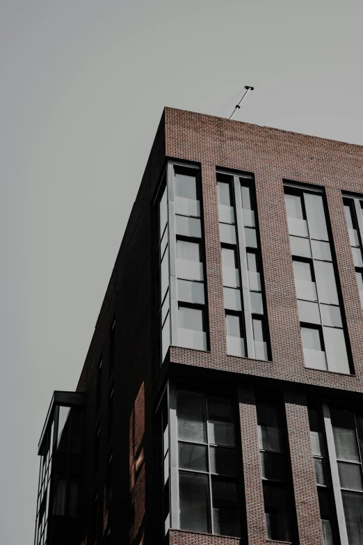 a tall brick building with an assortment of windows on the sides