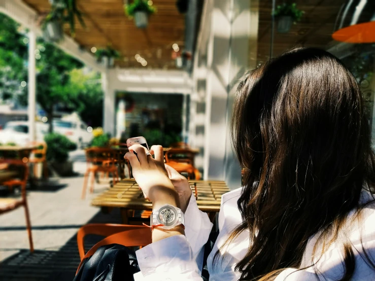 a woman sitting at a table with her cell phone